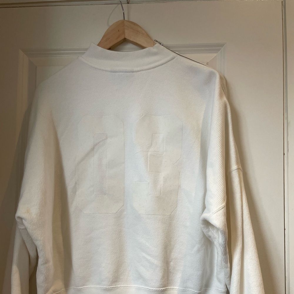 This is an Addis’s sweater. It has a zipper on the right shoulder. It is a US M
